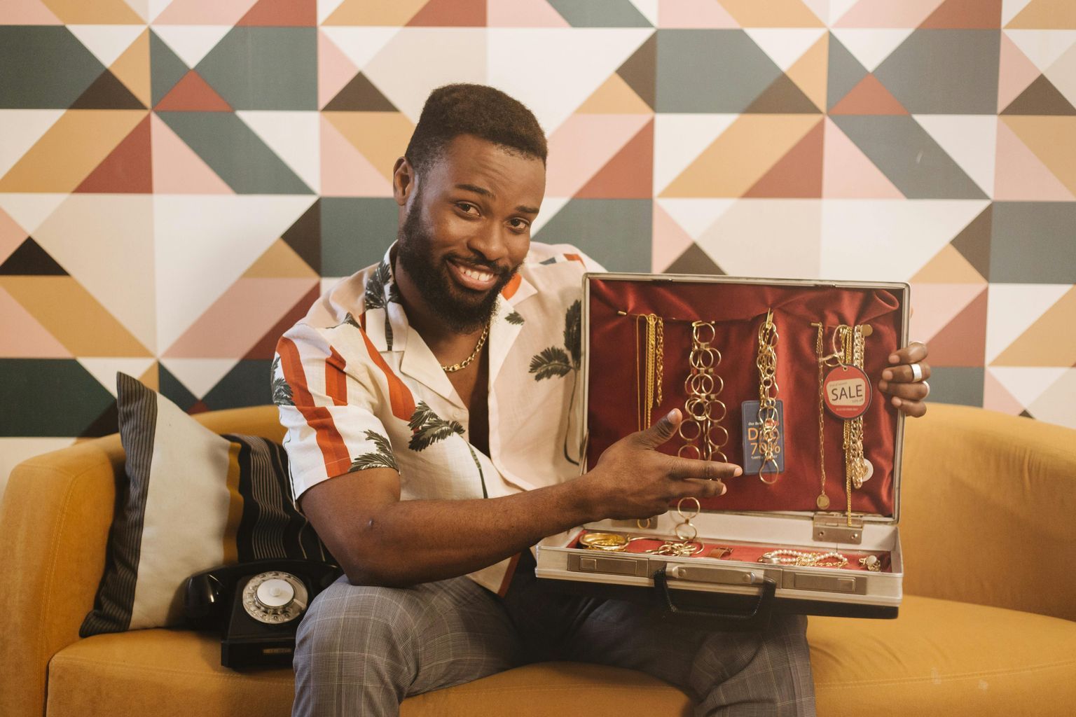 A Smiling Man Holding a Suitcase Full of Jewelry