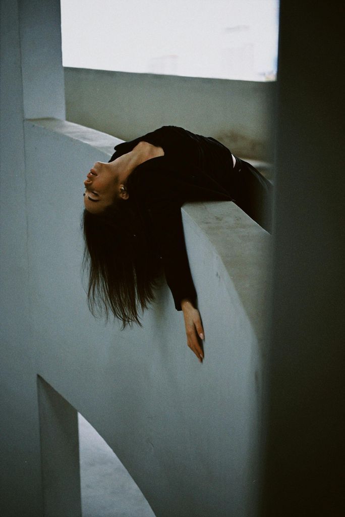 Woman Hanging Over Concrete Wall