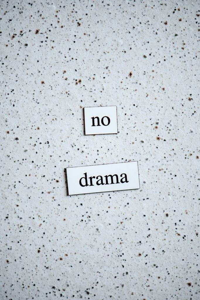 Words Saying "No Drama" on White Plaques on White Background with Black Dots